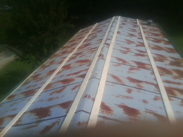 Rusted metal roof panels with new wood purlins before replacement — Storm Damage Roof Repair in Ponca by Roofing Brothers