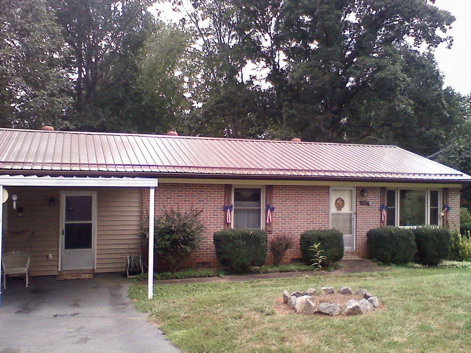 Bronze metal roof and carport on a brick ranch home — Roof Repair work by our crew in Ponca