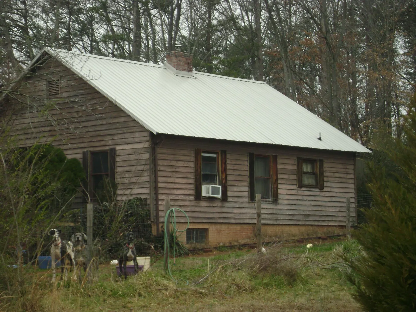White metal roof on an old wood sided farmhouse, from a Metal Roof Installation job in Ponca